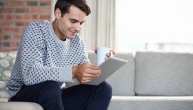 Mann mit Tablet beantragt online Immobilienbewertung